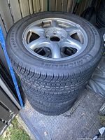 Stack of four mounted tires and rims seen from top