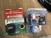 Photo showing the Fluidmaster Better Than Wax toilet seal kit, Iberville Pro-Pak box with screws, and additional sealed small packs of screws and wall anchors.