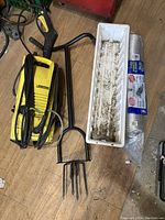 Karcher yellow pressure washer, black garden cultivator tool, white planter box, and pack of clear plastic cups.