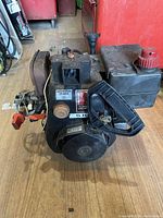 Close-up view of the small engine showing the recoil starter handle, engine block and primer button labeled 'AMORCEUR PRIMER'.