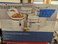 Photo of the 4-piece canister set in the original box showing the canisters and wooden spoons.