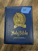 Blue hardcover Holy Bible titled Spirit of Liberty with gold foil emblem of soldiers and flag on front cover.