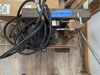 Top view showing air compressor motor and hose coiled on top with attached fittings.