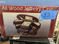 Photo of the jewelry case box showing image of wooden jewelry case with multiple compartments and a mirror.