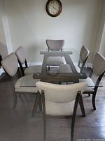 Rectangular glass top table with dark wood base viewed from side