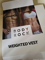 Front cover of the Body Rock weighted vest packaging showing male and female models wearing the vest, advertising the product.