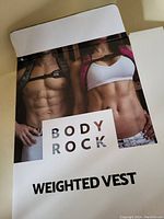 Front cover of packaging showing muscular man and woman and Body Rock Weighted Vest branding.