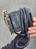 Close-up photo of Black & Decker electric sander showing sanding pad, power cord, and brand label.
