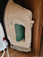 White and green Philips Azurite 2 steam iron, front and top showing dial and steam controls, cord wrapped at base.