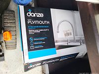 Original boxed Danze Plymouth 8 inch two-handle kitchen faucet showing front box design and brand logo.