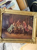 Framed oil-style painting showing five men from a historical period inside a room, the frame is gold with decorative corners