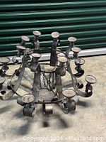 Full view of antique metal candle chandelier showing circular frame and multiple candle holders