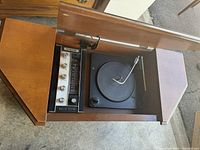 Top angled view showing open wooden console with black turntable and built-in radio with dials.