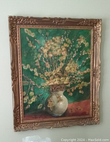 Photo of a framed floral still life painting with yellow flowers in a white vase against green background