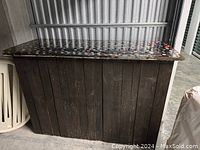 Front view of dark wooden bar with bottle cap covered resin top.