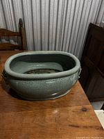 Green oval vase showing the overall shape and crackle glaze texture.