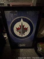 Framed Winnipeg Jets NHL licensed poster featuring the team logo and branding, with a black frame and glass cover.