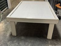 Side view of white wooden kids play table showing thick legs and frame