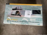 The box of an Axis Rack-Pack Roof Top Cargo Bag showing the product mounted on a car roof and description in English and French.