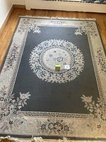 Full view of the rectangular area rug showing the central floral medallion and border designs.