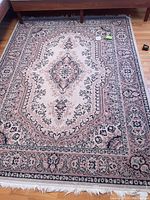 Full view of rectangular rug under furniture showing overall pattern and condition.