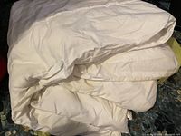 White queen size duvet folded and laid on a surface showing its texture and color.