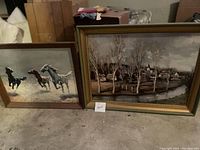 Wide angle showing two framed prints: running horses and rural landscape village scene