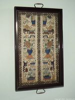 Framed antique Chinese silk embroidery panel with metal handles for hanging or serving use, showing full panel and wooden frame.