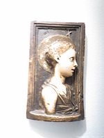 Front view of antique French plaster plaque with female figure profile and halo relief showing wear and cracks.