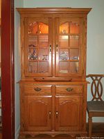 Front view of the solid wood china cabinet with glass doors showing internal shelving and lighting.