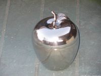 Photo of the outer side of the highly polished stainless steel apple showing reflective surface and stem on top