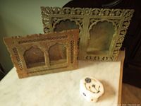 Two hand carved marble lattice picture frames and a small marble inlay trinket box on a marble surface