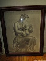 Framed detailed pencil drawing of a woman holding a child.