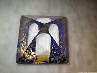 Top view of pyramid paperweight showing blue color, gold leaf accents and scarab design details.