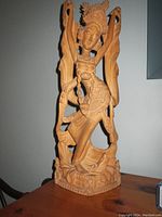 Full view of the carved wooden statue showing detailed figure and base, highlighting overall condition and size.