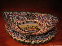 Handpainted vintage Turkish toleware saucer matching the serving dish with same intricate bird and floral patterns, scalloped edges, and beaten metal texture.
