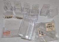 Photo showing a variety of clear plastic brochure holders and several 'Please Take One' holders including their cards.