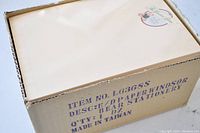 Cardboard box with printed label showing item number, description: E/D Paper Windsor Bear Stationery, quantity: 1 dozen, made in Taiwan.