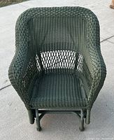 Front view of the green wicker rattan rocking chair showing woven seat and backrest with curved design.