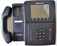 Front angled view of Pitney Bowes Philips Tele Ship model P100-B phone showing handset off the cradle, numeric keypad, and LCD screen.