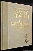 Front cover of The Good Housekeeping Family Health & Medical Guide Book showing white cover and gold embossed lettering with small corner damage.