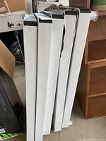 Five white plastic shelves stacked, one shelf shows a slight crack on the edge.