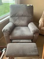 Front view of the gray fabric recliner chair showing cushioned armrests and backrest.