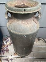 Top angle view of antique metal milk cream can with rust and patina visible, two side handles shown.