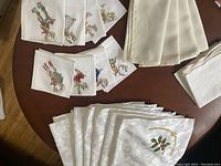 Photo of various Christmas embroidered white cloth napkins and white damask style table mats with holly embroidery
