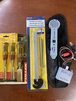 Full view of all items: three Fuller chisels in packaging, IronCraft telescoping basin wrench in packaging, and Wire Tracker tool with cables and carrying case.