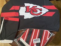 Black bed sheet with large Kansas City Chiefs logo and red stripes, showing design details and colors of the bed sheet and pillow cases.