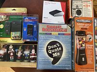Boxed assortment of new items including electronics, kitchen blender, board game, holiday decorations, and tools