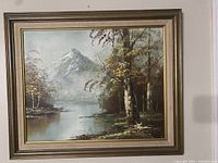 Framed oil painting showing mountain with snow, calm water, and birch trees in foreground.