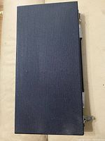 Closed view of textured travel case for pool cue, dark colored with silver latches